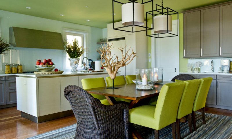 Матова натяжна стеля оливкового відтінку створює спокійну та природну атмосферу в просторій кухні. Поєднання дерев'яних елементів, зелених акцентів і сучасних світильників додає інтер'єру елегантності та гармонії.